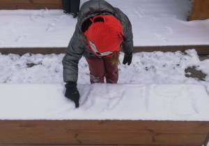 dziewczynka pisze na śniegu